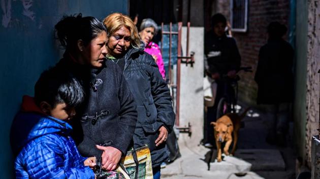 A long, silent line forms in the alley outside as women with toddlers, the elderly and disabled shuffle up to her kitchen door, shopping bags ready to take away food. Inside, women wearing aprons and hair covers ladle meat and vegetables from the pots into Tupperware containers. (Ronaldo Schemidt / AFP)
