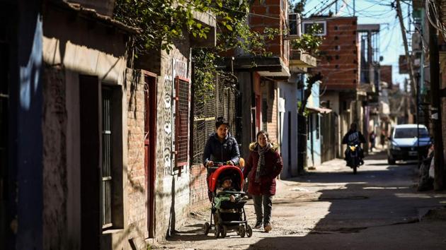 People walk at the Villa 21-24 shantytown. President Mauricio Macri, seeking re-election in October, had promised to reach the goal of “zero poverty” during his term. Instead, poverty has deepened to reach 32% of the population, according to official figures. (Ronaldo Schemidt / AFP)