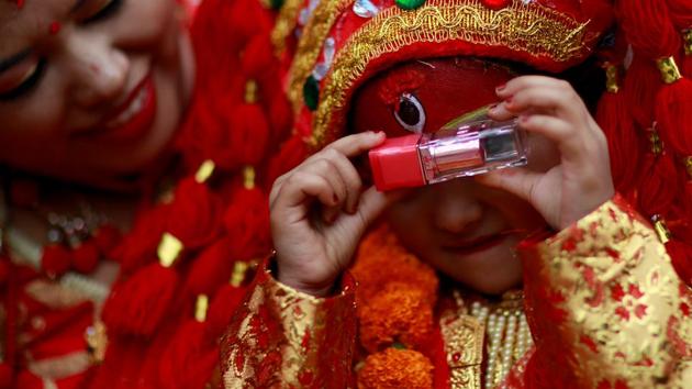A young girl dressed as the Living Goddess Kumari looks through a lipstick during the Kumari Puja festival, in which young girls pose as the Kumari and are worshipped by people in belief that their children will remain healthy, in Kathmandu, Nepal. (Navesh Chitrakar / REUTERS) A young girl dressed as the Living Goddess Kumari looks through a lipstick during the Kumari Puja festival, in which young girls pose as the Kumari and are worshipped by people in belief that their children will remain healthy, in Kathmandu, Nepal. (Navesh Chitrakar / REUTERS)