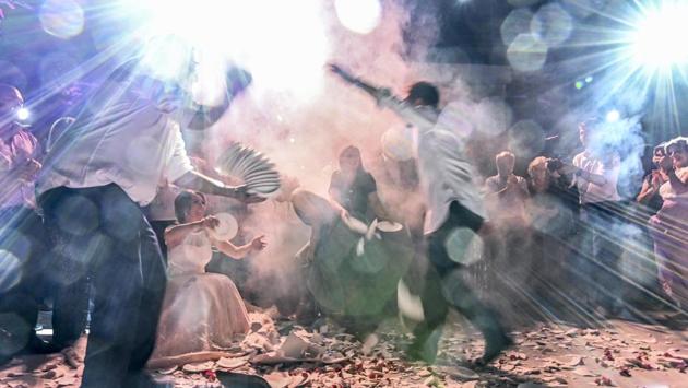 People dance to a traditional Greek music amid broken plates, during a wedding celebrations in Athens, Greece. (Louisa Gouliamaki / AFP) People dance to a traditional Greek music amid broken plates, during a wedding celebrations in Athens, Greece. (Louisa Gouliamaki / AFP)