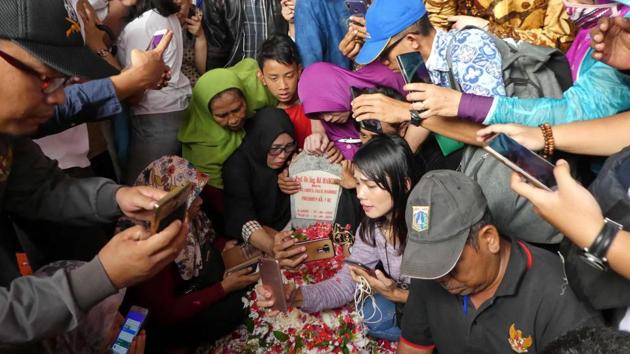 People try to take selfies at the grave of Indonesia’s former President B.J. Habibie following his funeral ceremony in Jakarta. Habibie, who ushered in an era of democratic reforms after the downfall of long-time dictator Suharto, died on September 11 at the age of 83 in Jakarta. (Bay Ismoyo / AFP) People try to take selfies at the grave of Indonesia’s former President B.J. Habibie following his funeral ceremony in Jakarta. Habibie, who ushered in an era of democratic reforms after the downfall of long-time dictator Suharto, died on September 11 at the age of 83 in Jakarta. (Bay Ismoyo / AFP)