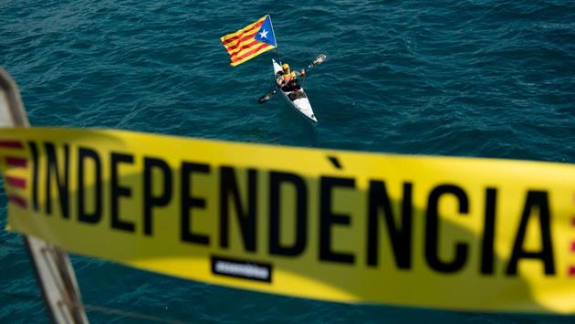 A man rows in a Kayak with an “Estelada”, the Catalan pro-independence flag, as in the foreground a banner reads in Catalan “Independence” during a pro-independence gathering under the motto “Wave for the Independence” in Badalona ahead of the celebration of the National Day of Catalonia, Diada. (Josep Lago / AFP) A man rows in a Kayak with an “Estelada”, the Catalan pro-independence flag, as in the foreground a banner reads in Catalan “Independence” during a pro-independence gathering under the motto “Wave for the Independence” in Badalona ahead of the celebration of the National Day of Catalonia, Diada. (Josep Lago / AFP)