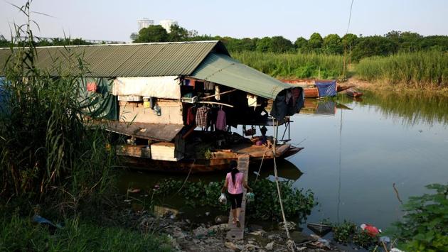 A woman carrying vegetables for dinner returns to the floating guesthouse where she lives. That’s $8 is four times what Nguyen Thi Hong earned at a rural garment factory. “I couldn’t earn enough money to raise my kids,” she said, explaining that her three children are back home with their father in Ba Vi, 60 kilometres from Hanoi. “So I moved here.” (Manan Vatsyayana / AFP) A woman carrying vegetables for dinner returns to the floating guesthouse where she lives. That’s $8 is four times what Nguyen Thi Hong earned at a rural garment factory. “I couldn’t earn enough money to raise my kids,” she said, explaining that her three children are back home with their father in Ba Vi, 60 kilometres from Hanoi. “So I moved here.” (Manan Vatsyayana / AFP)