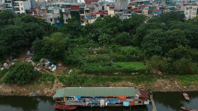 A floating guesthouse for migrant workers on the banks of the Red River. Temporary residents of these open-air boats have left the countryside in search of higher wages in the city. Wages in Vietnam’s cities are at least double those of the countryside in a nation where the World Bank says the average annual income is around $2,600. (Manan Vatsyayana / AFP) A floating guesthouse for migrant workers on the banks of the Red River. Temporary residents of these open-air boats have left the countryside in search of higher wages in the city. Wages in Vietnam’s cities are at least double those of the countryside in a nation where the World Bank says the average annual income is around $2,600. (Manan Vatsyayana / AFP)