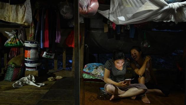 Women watch a video after having their meals at sunset. Such workers struggle to access “decent work and government services” and are vulnerable to sexual or labour abuse, said Nguyen Quoc Nam of the International Organization for Migration in Hanoi. (Manan Vatsyayana / AFP) Women watch a video after having their meals at sunset. Such workers struggle to access “decent work and government services” and are vulnerable to sexual or labour abuse, said Nguyen Quoc Nam of the International Organization for Migration in Hanoi. (Manan Vatsyayana / AFP)