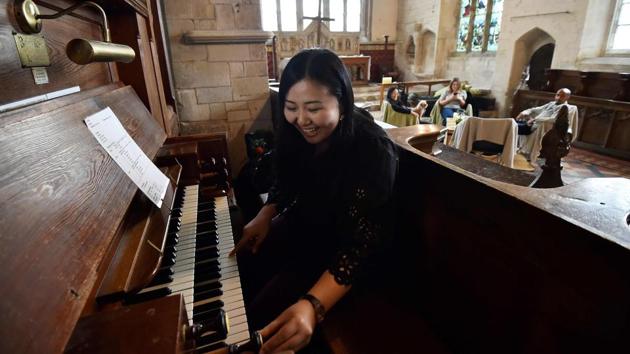University student Kae Ono plays the church organ while her friends relax in the background. “I love it, did you see the trees? Creepy, amazing!,” says fellow camper Lingbo Zhou. Ono blasts out gothic riffs from “The Phantom of the Opera” on the church organ, which comes as part of the deal. (Glyn Kirk / AFP)