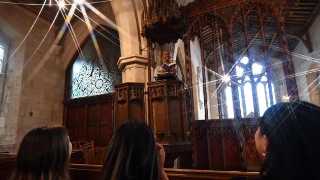 Guest Ismail Abdirahman (top) reads to his friends Andrea Stewart, Lingbo Zhou and Kae Ono from the pulpit at St Mary’s Church, where guests can pay to stay overnight in what is known as ‘champing’—short for church camping, in Edlesborough, Buckinghamshire. Silent night, holy night takes on a whole new meaning for visitors paying for an unorthodox overnight stay in a mediaeval English church. (Glyn Kirk / AFP)