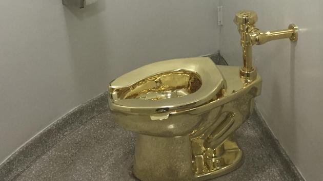 In this file photo taken on September 15, 2016, a fully functioning solid gold toilet, made by Italian artist Maurizio Cattelan, is going into public use at the Guggenheim Museum in New York. - Thieves have stolen an 18-karat gold toilet from an exhibition of artworks at Britain's Blenheim Palace, police said Saturday -- causing signficant flooding. The fully-functioning piece by Italian artist Maurizio Cattelan, dubbed "America", went on show at the southern English stately home on Thursday. (Photo by William EDWARDS / AFP)(AFP)