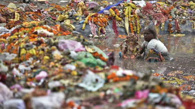 A woman collects an idol of Lord Ganesh from a water pond a day after Ganesh Chaturthi celebrations, at Geeta Colony, in New Delhi. People were barred from immersing idols in the Yamuna. (Raj K Raj/HT Photo)