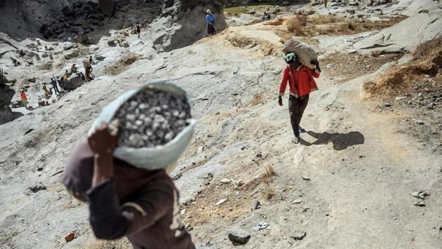 Workers from the Father Opeka’s association Akamasoa carry stones and grabble from a Granite quarry. The town’s white walls contrast with the filth of Antananarivo’s streets. Painted slogans say “No speaking, we are working.” (Gianluigi Guercia / AFP) Workers from the Father Opeka’s association Akamasoa carry stones and grabble from a Granite quarry. The town’s white walls contrast with the filth of Antananarivo’s streets. Painted slogans say “No speaking, we are working.” (Gianluigi Guercia / AFP)