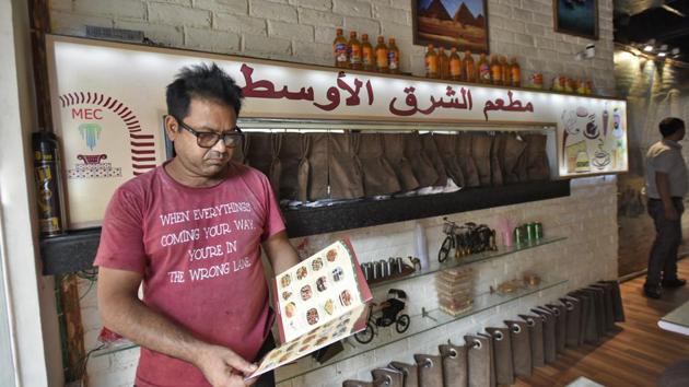 Ashoor is in Delhi for his father’s surgery. “He wanted Arabic food and Jasola-Sarita Vihar is the only place where one can get good and affordable Arabian cuisine,” said Riazuddin. The walls of the eatery are lined with framed pictures of Arab cities, and an Iraqi flag runs across the brick wall. “This was his (the chef’s) way of remembering his own country,” says Idrees Ahmad, a manager at the restaurant. (Burhaan Kinu / HT Photo)