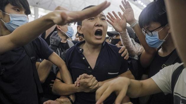 Protesters detain suspected Chinese undercover agent during a demonstration at the Airport. The protest at the airport led to the cancellation of hundreds of flights and clashes between demonstrators and police which China deemed “behaviour that is close to terrorism”. Hong Kong police admitted deploying officers disguised as anti-government protesters during the standoff. (Vincent Yu / AP) Protesters detain suspected Chinese undercover agent during a demonstration at the Airport. The protest at the airport led to the cancellation of hundreds of flights and clashes between demonstrators and police which China deemed “behaviour that is close to terrorism”. Hong Kong police admitted deploying officers disguised as anti-government protesters during the standoff. (Vincent Yu / AP)
