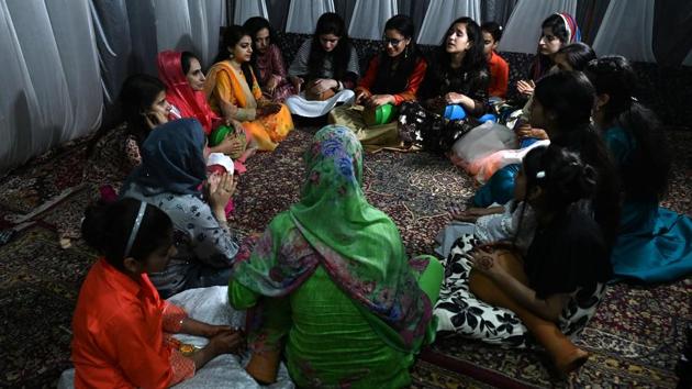 Women sing at a marriage ceremony. The marketing manager had originally planned a three-day extravaganza, including a make-up session, music, and a huge canopy to accommodate more than 700 guests invited to partake in the traditional Kashmiri wazwan feast. “I grew up dreaming about a grand wedding but there is not much to celebrate because of the situation,” the 29-year-old told AFP. (Tauseef Mustafa / AFP)