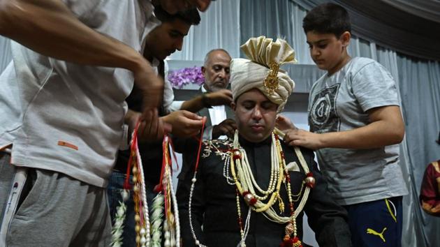 A groom is garlanded by relatives and friends before leaving for his bride's home in Kashmir's Baramulla. Parents start preparing for their child’s marriage almost immediately after birth, Bilal said. So when only 15% of the invited guests turned up for his brother’s wedding last month, “it was a heartbreak for the family,” he said. (Tauseef Mustafa / AFP)