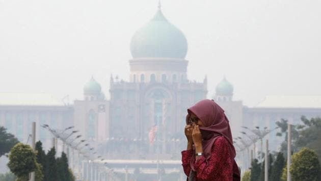 A woman covers her face with a scarf in front of the Malaysia’s Prime Minister’s office. Nearly every year, Indonesian forest fires spread health-damaging haze across the country and into neighboring Malaysia and Singapore. The fires are often started by smallholders and plantation owners who set land on fire as a cheap way of clearing it for new planting. (Lim Huey Teng / REUTERS) 