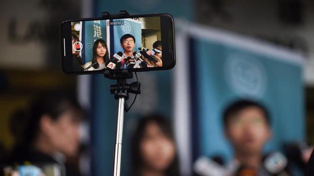 A journalist films pro-democracy activists Agnes Chow (L) and Joshua Wong (R) after they were released on bail on August 30. The prominent democracy activists including a lawmaker were arrested in a dragnet across Hong Kong -- a move described by rights groups as a well-worn tactic deployed by China to suffocate dissent ahead of key political events. (Lilian Suwanrumpha / AFP) A journalist films pro-democracy activists Agnes Chow (L) and Joshua Wong (R) after they were released on bail on August 30. The prominent democracy activists including a lawmaker were arrested in a dragnet across Hong Kong -- a move described by rights groups as a well-worn tactic deployed by China to suffocate dissent ahead of key political events. (Lilian Suwanrumpha / AFP)