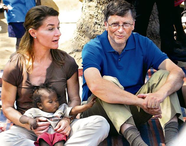 Microsoft founder and philanthopist Bill Gates (R) looks on as his wife Melinda holds a toddler during their visit to a village at Patna district in Bihar(AP FILE)