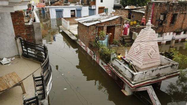 People look on from the top of their houses surrounded by flood waters in Prayagraj. Adityanath had conducted an aerial survey of the affected areas in Ballia on Tuesday and distributed relief material. He asked officials of the irrigation department to ensure the safety of bridges and embankments by undertaking regular inspections so that remedial steps can be taken. (Rajesh Kumar Singh / AP) People look on from the top of their houses surrounded by flood waters in Prayagraj. Adityanath had conducted an aerial survey of the affected areas in Ballia on Tuesday and distributed relief material. He asked officials of the irrigation department to ensure the safety of bridges and embankments by undertaking regular inspections so that remedial steps can be taken. (Rajesh Kumar Singh / AP)