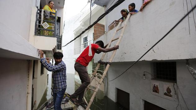 A man uses a ladder to get on a boat from a house surrounded by flood waters on Wednesday. In one case of helplessness, Chhedilal Nishad, a local resident said that he and his family had turned a boat into their home which has been flooded. “We are forced to live on the boat because of the impending situation. No one from the government has visited this area yet,” he said. (Rajesh Kumar Singh / AP) A man uses a ladder to get on a boat from a house surrounded by flood waters on Wednesday. In one case of helplessness, Chhedilal Nishad, a local resident said that he and his family had turned a boat into their home which has been flooded. “We are forced to live on the boat because of the impending situation. No one from the government has visited this area yet,” he said. (Rajesh Kumar Singh / AP)