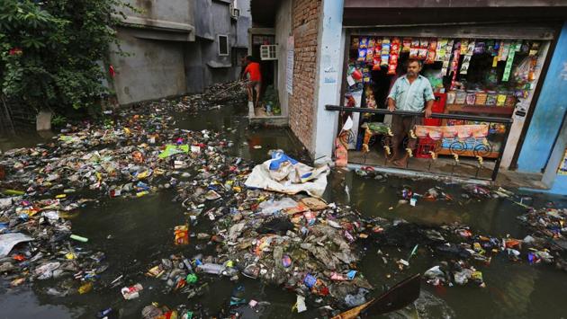A shop keeper looks at garbage brought in by flood waters in Prayagraj. Earlier, as many as 210 people were moved into relief camps near Ganganagar village in the district after water burst into a few villages as rivers continue to swell owing to heavy rainfall in the region. (Rajesh Kumar Singh / AP) A shop keeper looks at garbage brought in by flood waters in Prayagraj. Earlier, as many as 210 people were moved into relief camps near Ganganagar village in the district after water burst into a few villages as rivers continue to swell owing to heavy rainfall in the region. (Rajesh Kumar Singh / AP)