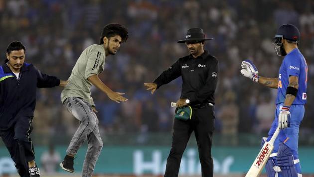 A security personnel, second from left, tries to stop a fan of India's captain Virat Kohli.(AP)
