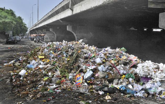 A heap of garbage under the flyover near the bus stand in Ludhiana on Wednesday.(HT PHOTO)