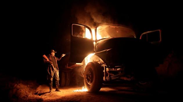 With no space to bring the captured scout to the police, the guardians leave him in the forest to be retrieved by his colleagues. After failing to start the logging trucks they have seized, the guardians burn them to make sure they are not used again. “We asked them to leave, and they didn’t,” says Laercio. “We’re burning the trucks now to show our response.” (Ueslei Marcelino / REUTERS) With no space to bring the captured scout to the police, the guardians leave him in the forest to be retrieved by his colleagues. After failing to start the logging trucks they have seized, the guardians burn them to make sure they are not used again. “We asked them to leave, and they didn’t,” says Laercio. “We’re burning the trucks now to show our response.” (Ueslei Marcelino / REUTERS)
