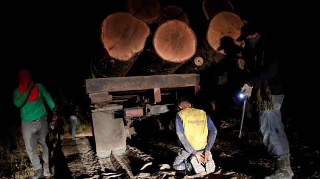 Guajajara Indians “forest guardians” detain a logger during a search for illegal loggers on Arariboia indigenous land near the city of Amarante, Maranhao state, Brazil. The police are not coming, but the natives have a plan to fight back. The men say they are among some 180 guardians patrolling their tribal land against loggers on night missions. (Ueslei Marcelino / REUTERS) Guajajara Indians “forest guardians” detain a logger during a search for illegal loggers on Arariboia indigenous land near the city of Amarante, Maranhao state, Brazil. The police are not coming, but the natives have a plan to fight back. The men say they are among some 180 guardians patrolling their tribal land against loggers on night missions. (Ueslei Marcelino / REUTERS)