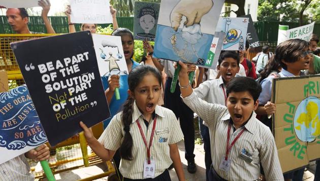 School students and members of the general public gather with placards while raising slogans to save the environment in front of the Ministry of Housing and Urban Affairs in New Delhi.(Vipin Kumar/HT PHOTO)