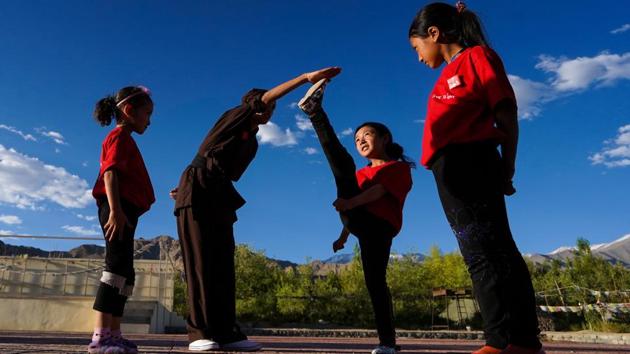 A nun helps students get a move down pat. Kung Fu is a lucrative means of drawing in participants, but the nuns also lead by example during the workshop with their social service –they rid pathways of litter as they pass and rescue animals they come across, for instance. The hope is such small actions will trickle into the larger social consciousness. (Hemanshi Kamani / HT Photo) 