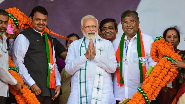 Prime Minister Narendra Modi, Maharashtra Chief Minister Devendra Fadnavis and BJP Maharashtra president Chandrakant Patil being garlanded by supporters during the 'Vijay Sankalp Rally' in Nashik.(PTI photo)