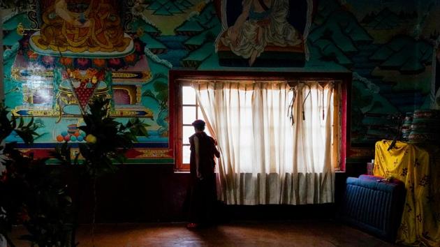 A nun gazes out from a temple window in Shey village. Many of the older nuns focus their time inwards, spending lives within the monastic order and refraining from public appearances or interactions. The Kung Fu nuns invert that norm while sticking to and spreading their core values. (Hemanshi Kamani / HT Photo) 