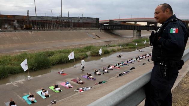 People take part in a yoga class near the border wall next to Rio Grande river in the border between El Paso, US, and Ciudad Juarez, Mexico. (Herika Martinez / AFP) People take part in a yoga class near the border wall next to Rio Grande river in the border between El Paso, US, and Ciudad Juarez, Mexico. (Herika Martinez / AFP)