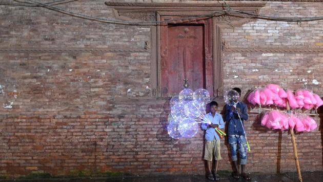 Young street vendors look on in the Hanuman Dhoka Durbar area on the second last day of the Indra Jatra festival in Kathmandu, Nepal. (Prakash Mathema / AFP) Young street vendors look on in the Hanuman Dhoka Durbar area on the second last day of the Indra Jatra festival in Kathmandu, Nepal. (Prakash Mathema / AFP)