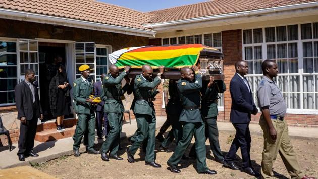 Pallbearers carry the coffin of former Zimbabwe President Robert Mugabe for a mass at the family homestead in Kutama village. The remains arrived for a subdued farewell after a weekend state funeral with African leaders in the capital. (Zinyange Auntony / AFP) Pallbearers carry the coffin of former Zimbabwe President Robert Mugabe for a mass at the family homestead in Kutama village. The remains arrived for a subdued farewell after a weekend state funeral with African leaders in the capital. (Zinyange Auntony / AFP)