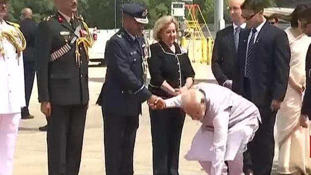 Prime Minister Modi picks up the flowers and hands it over to one of his security personnel.(Photo:Screengrab/Rajya Sabha TV)