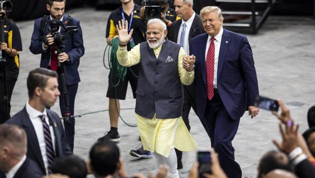 Narendra Modi, India's prime minister, center left, and US President Donald Trump hold hands while leaving the Howdy Modi Community Summit in Houston, Texas.(Bloomberg)