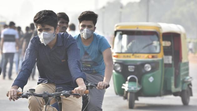 Commuters wearing anti-pollution masks as they rode amid a thick layer of smog at Rajpath in New Delhi in November 2018.(Sonu Mehta/HT File PHOTO)