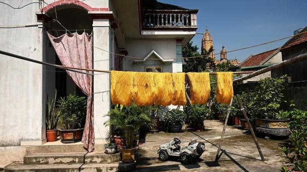 Silk threads hung out to dry in the compound of a home in Co Chat village. “Production from the silkworm cocoons depends 90% on the weather,” said workshop owner Pham Van Ba, whose family has been spinning thread for three generations. (Manan Vatsyayana / AFP)