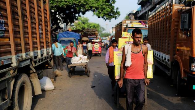 A worker pulls a cart past trucks at a wholesale market in Delhi, India. The government’s measures have significant positive implications for profitability of companies, the economy and stock valuations, brokerages said.(Photo: Bloomberg)