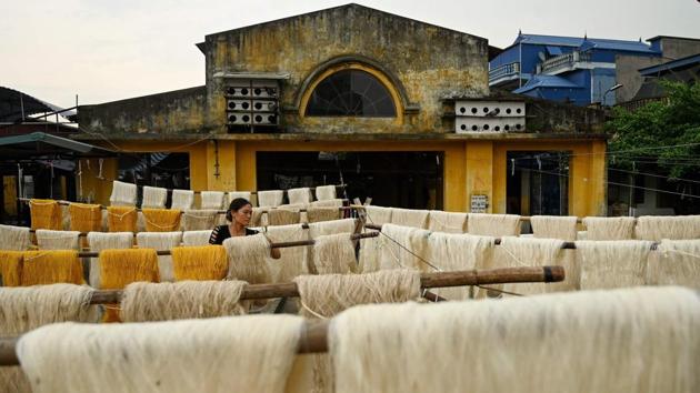 A worker checks on yarns of white and yellow silk collected to dry in an open courtyard. Around 30 kilograms of cocoons are processed by each worker every day, and the final threads are sold to traders exporting to Laos and Thailand. (Manan Vatsyayana / AFP)