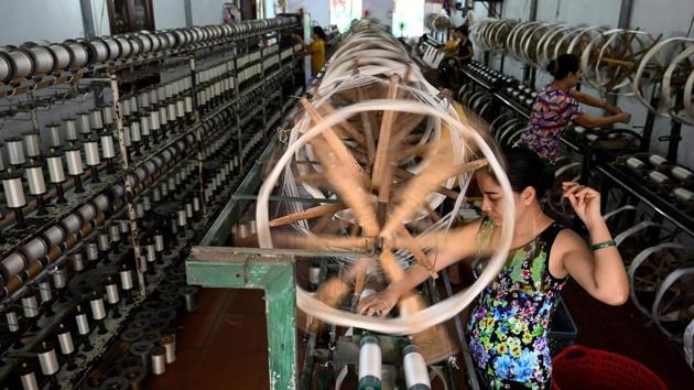 A worker spinning finished silk thread bobbins at a workshop. Each labourer earns around $10 a day, but worker Tran Thi Hien describes the work as “precarious”. “If the market price goes up, then we make some profit. Otherwise, it’s only enough to cover our expenses,” the 37-year-old said. (Manan Vatsyayana / AFP)