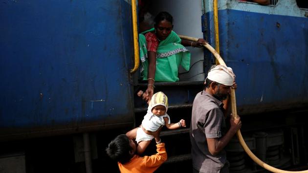 Jyoti Dhage passes her daughter Akansha to her son Siddharth at Aurangabad railway station. “Some people help me, sometimes they complain to railway officials for putting pitchers near the door. If we don’t put them near the door, we cannot take them out quickly when the train stops,” Siddharth said. (Francis Mascarenhas / REUTERS) Jyoti Dhage passes her daughter Akansha to her son Siddharth at Aurangabad railway station. “Some people help me, sometimes they complain to railway officials for putting pitchers near the door. If we don’t put them near the door, we cannot take them out quickly when the train stops,” Siddharth said. (Francis Mascarenhas / REUTERS)
