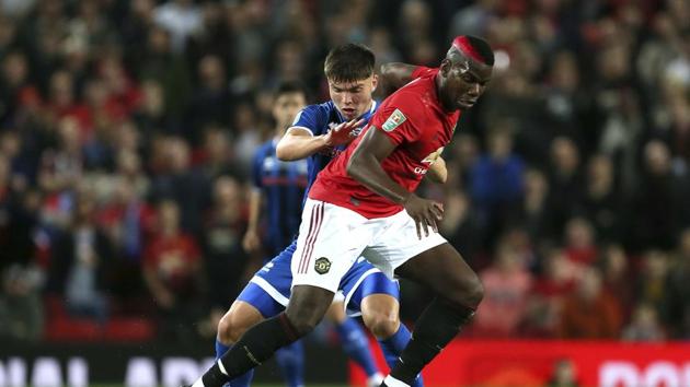 Rochdale's Aaron Morley, left, and Manchester United's Paul Pogba battle for the ball during their English League Cup, Third Round match.(AP)