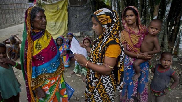 A Muslim woman checks for names in the final list of the National Register of Citizens (NRC) on a printed sheet of paper in Pabhokati village in Morigaon district, in the northeastern Indian state of Assam, Saturday, August. 31, 2019.(AP file photo)