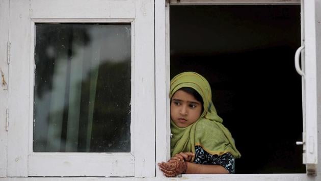 A girl watches a protest from the window of a shrine in Srinagar. On September 20, the Supreme Court directed the Jammu and Kashmir High Court’s Juvenile Justice Committee to investigate allegations of illegal detention of children by security forces. (Mukhtar Khan / AP) A girl watches a protest from the window of a shrine in Srinagar. On September 20, the Supreme Court directed the Jammu and Kashmir High Court’s Juvenile Justice Committee to investigate allegations of illegal detention of children by security forces. (Mukhtar Khan / AP)