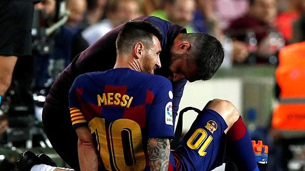 Barcelona's Lionel Messi is attended by medical staff after sustaining an injury.(REUTERS)