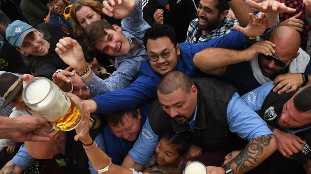 Visitors reach for a beer mug during the opening of the Oktoberfest beer festival in a festival tent at the Theresienwiese fair grounds in Munich, southern Germany. (Christof Stache / AFP) Visitors reach for a beer mug during the opening of the Oktoberfest beer festival in a festival tent at the Theresienwiese fair grounds in Munich, southern Germany. (Christof Stache / AFP)