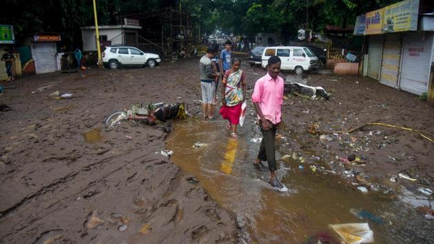 People cross a muddied street near Tangewale colony in Pune. Incidents of wall collapse were also recorded in Pune city. When asked if unauthorized constructions exacerbated the situation, Pune commissioner Saurabh Rao said action will be taken against such structures. (Sanket Wankhade / HT Photo) People cross a muddied street near Tangewale colony in Pune. Incidents of wall collapse were also recorded in Pune city. When asked if unauthorized constructions exacerbated the situation, Pune commissioner Saurabh Rao said action will be taken against such structures. (Sanket Wankhade / HT Photo)
