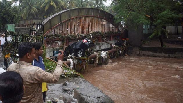Onlookers and residents take photos of a car washed away by flash floods in Pune on Thursday. A civic official said that as many as 175 vehicles were washed away in floods. Pune commissioner Saurabh Rao said the city recorded 106 mm of rain on Thursday. (Jignesh Mistry / AFP) Onlookers and residents take photos of a car washed away by flash floods in Pune on Thursday. A civic official said that as many as 175 vehicles were washed away in floods. Pune commissioner Saurabh Rao said the city recorded 106 mm of rain on Thursday. (Jignesh Mistry / AFP)